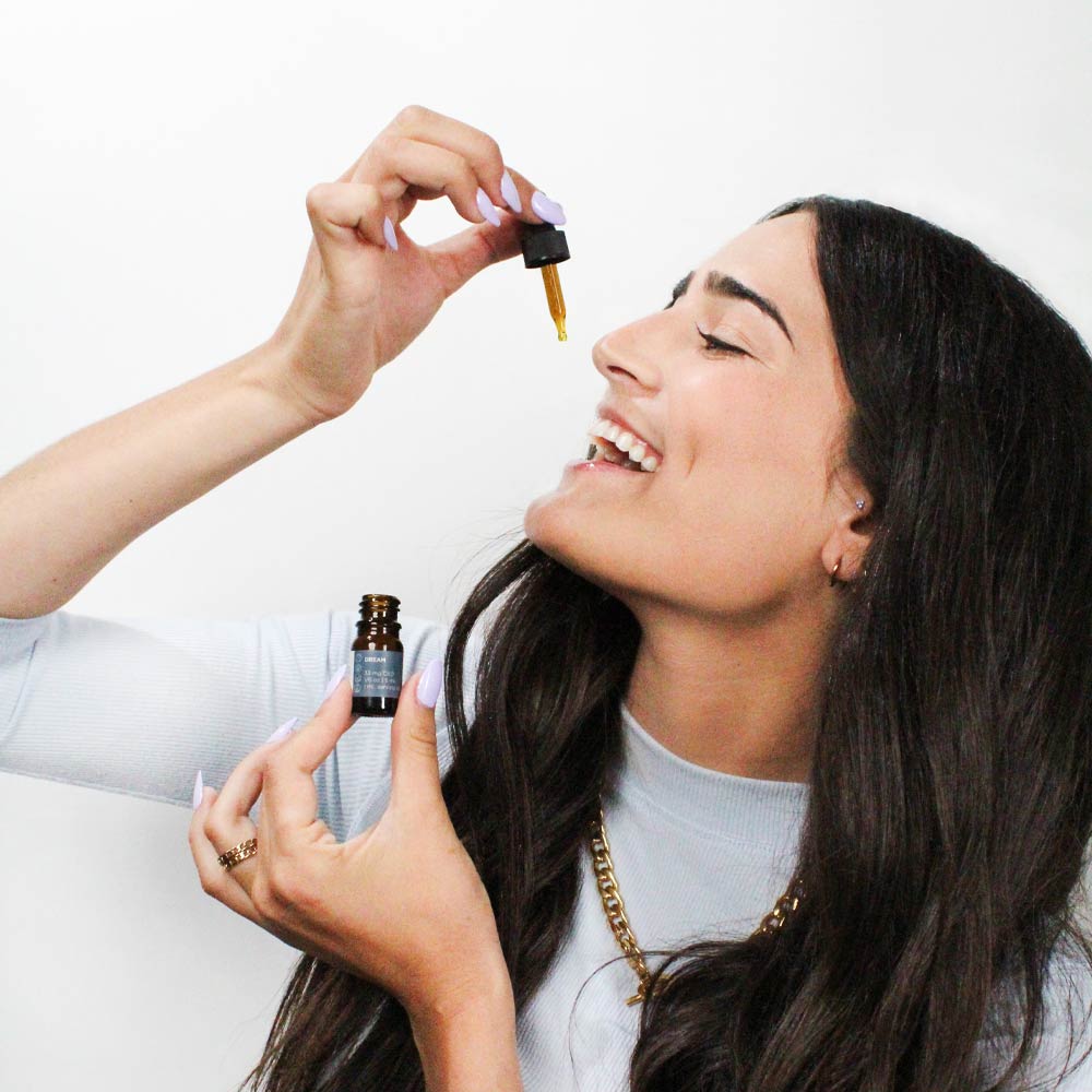 model taking a cbd tincture dose