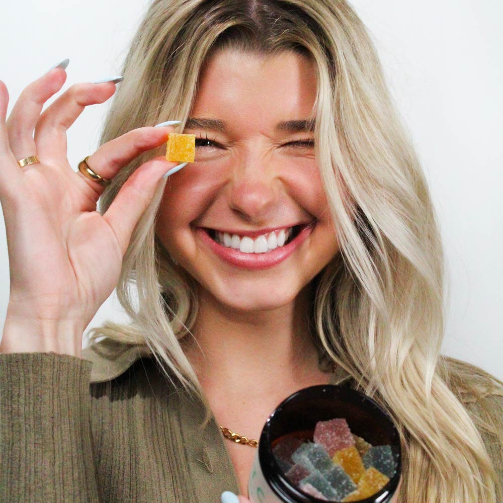 model holding an all-natural, non-GMO CBD gummy